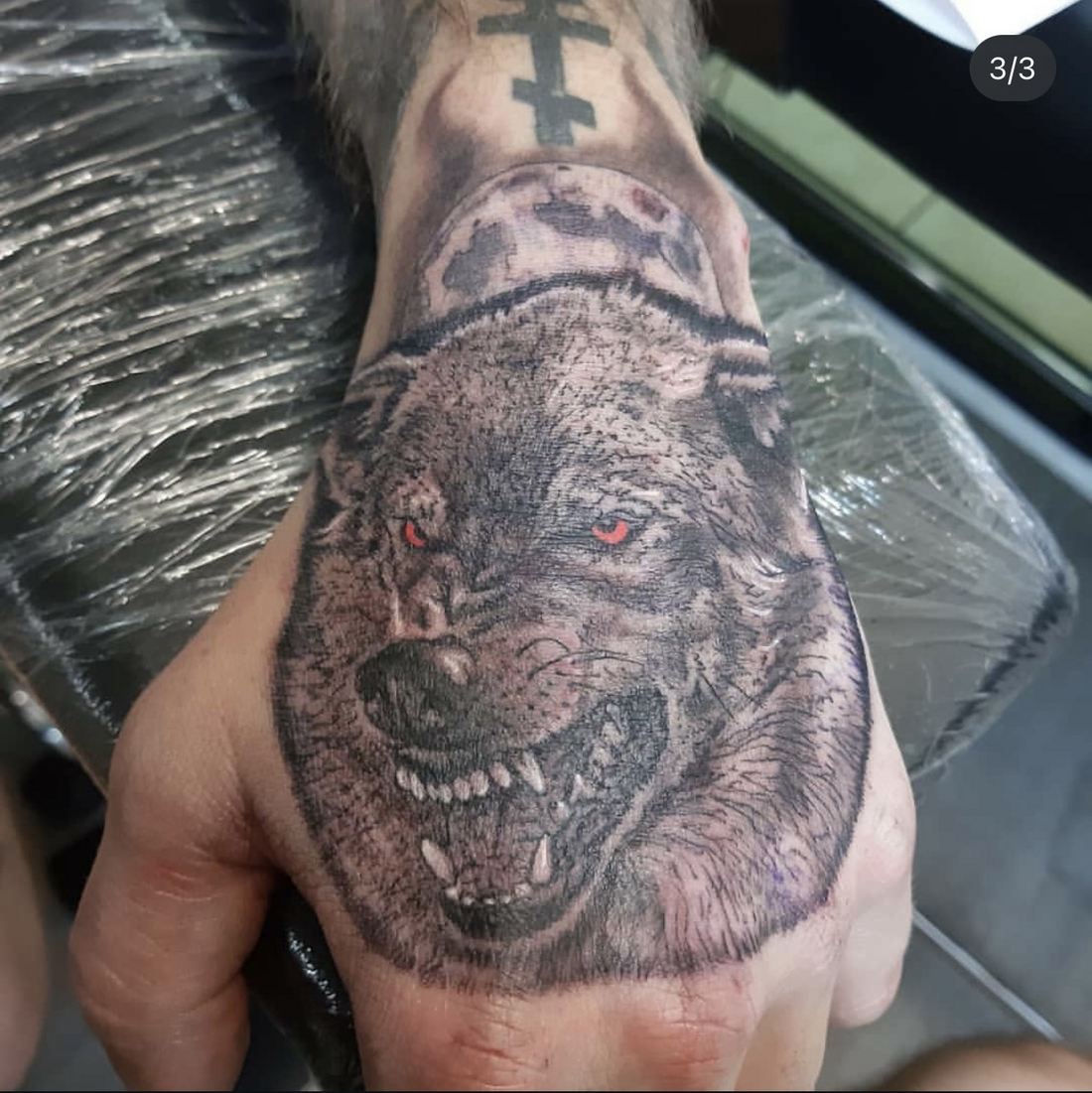 Tattoo: Black & grey — Red-eyed wolf hand piece